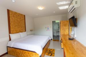 a bedroom with a bed and a flat screen tv at Sakul Plang Resort in Wang Saphung