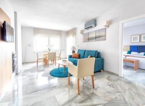 a living room with a blue couch and a table at First Flatotel International in Benalmádena