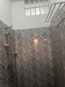 a bathroom with a shower with a stone wall at Vhomes in Apéyémé +48 photos