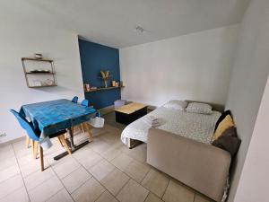 un soggiorno con un letto e un tavolo di La Maisonnette a Haubourdin