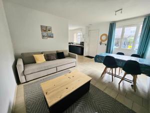 a living room with a couch and a table at La Maisonnette in Haubourdin
