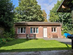 una piccola casa in mattoni con tavolo e sedie in cortile di La Maisonnette a Haubourdin