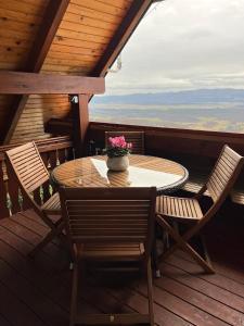 a table and chairs on the deck of a cabin at Vineyard cottage Skriti raj in Leskovec pri Krškem +32 photos