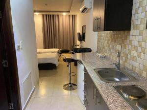 Una cocina con fregadero y una habitación con cama. en 7 Days Hotel, en Umm Uthainah 92 fotos más