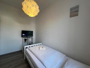 a bedroom with a bed and a yellow light at Vollausgestatte Wohnung mit, WLAN, TV in jedem Schlafzimmer, Einzelbetten, Bad, Garten in Crimmitschau