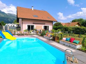 a swimming pool in front of a house at Maison avec piscine 14 personnes in Doussard