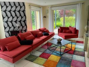 a living room with red couches and a colorful rug at Maison avec jardin Gérardmer L'AUTOUR in Gérardmer