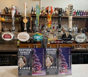a bar with a bunch of signs on the counter at Kings Hotel in Newmarket