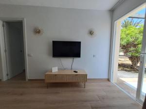 Televízia a/alebo spoločenská miestnosť v ubytovaní HomeForGuest Apartamento 15 con terraza y piscina en Corralejo