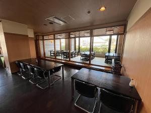 ein Esszimmer mit Tischen und Stühlen und Fenstern in der Unterkunft Hotel Marsh Land in Kushiro + 37 Fotos