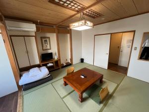 ein Wohnzimmer mit Tisch und Couch in der Unterkunft Hotel Marsh Land in Kushiro