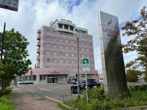 een gebouw met een bord voor een parkeerplaats bij Lasting Hotel in Kushiro