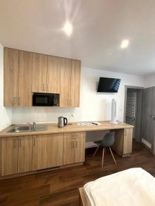 a kitchen with wooden cabinets and a desk with a sink at Apartament Residence Nysa in Nysa