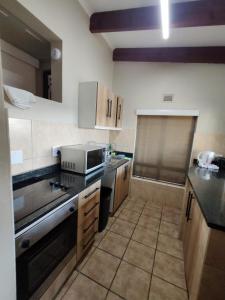 a kitchen with a sink and a stove top oven at Chakas Rock Chalets - Unit 19 in Ballito