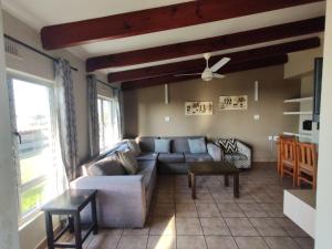 a living room with a couch and a table at Chakas Rock Chalets - Unit 19 in Ballito