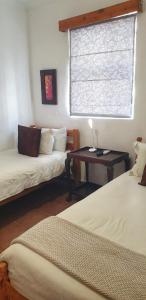 a room with two beds and a table with a window at Camdeboo Cottages in Graaff-Reinet +163 photos