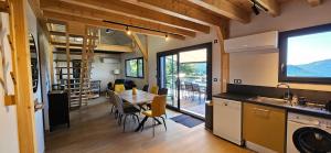 a kitchen and dining room with a table and chairs at 3 Chalets avec vue imprenable et SPA in Queyrières