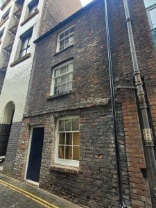 a brick building with a window on a street at 10 Hockenhall - Liverpool's Oldest House in Liverpool