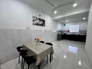 a table with chairs and a vase of flowers on it at DH Homestay in Sungai Petani