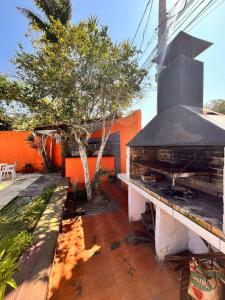 an outdoor grill with a bench and a tree at Bella vida Geriba suites in Búzios