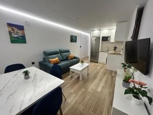 a living room with a blue couch and a table at 1ª planta D Apartamento Juan Robledo en centro ciudad, in Andújar