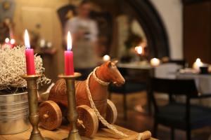 une figurine d'un cheval sur une table avec des bougies dans l'établissement Maison Bondaz & SPA privé, à Aoste