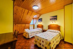 a bedroom with two beds and a wooden ceiling at Hostal Pañart in Bielsa +20 photos