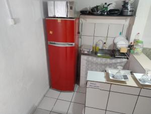 a small kitchen with a red refrigerator in the corner at Kitnet aconchegante in Olinda