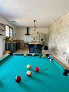 a pool table with balls on it in a room at Bâtisse au cœur du Gers in Leboulin