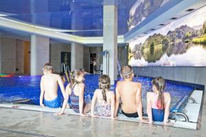 a group of people sitting in a swimming pool at Aparthotel Apartamenty Czarna Góra 139 in Sienna