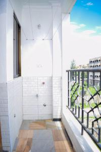 a room with a balcony with a shower and a window at Lux Suites Casey's Apartments Bamburi in Bamburi