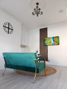 ein Wohnzimmer mit einem grünen Sofa und einem Kronleuchter in der Unterkunft The Greenhouse near Leeds City Centre in Killingbeck