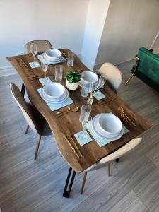 ein Holztisch mit Tellern und Gläsern darauf in der Unterkunft The Greenhouse near Leeds City Centre in Killingbeck + 21 Fotos