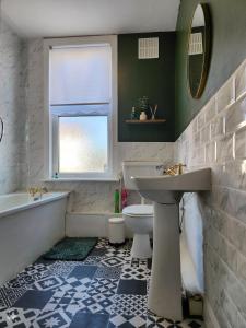 ein Badezimmer mit Waschbecken, Badewanne und Toilette in der Unterkunft The Greenhouse near Leeds City Centre in Killingbeck