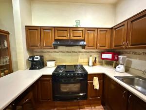 a kitchen with wooden cabinets and a black stove top oven at Yoo House - Hab6 in Oaxaca City