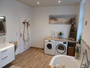 a bathroom with a washing machine and a sink at Familienfreundliches-luxus-Bahnwärterhaus in Schiltach