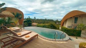 a swimming pool with lounge chairs next to a house at Villa La Quartz Seaview 2BR in Chaweng Noi Beach