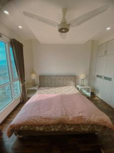 a bedroom with a large bed with a ceiling fan at 01 BHK CONDO IN FRONT OF CENTORUs in Islamabad
