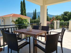 a wooden table and chairs on a balcony at Stunning View Villa in Sami in Chaliotata