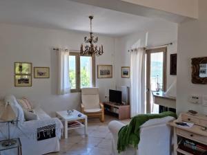 a living room with white furniture and a chandelier at Stunning View Villa in Sami in Chaliotata