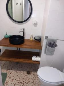a bathroom with a sink and a toilet and a mirror at Apartamento Mar y Arena in Cullera