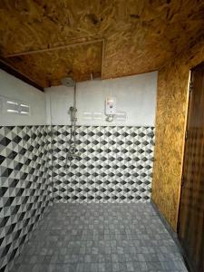 a bathroom with a shower with a tiled wall at Koh Jum Hillside Resort in Ban Ko Phrao
