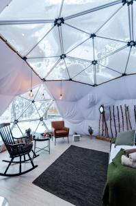 a room with a tent with a couch and a chair at GLØD Aurora Canvas Dome in Alta