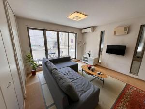 a living room with a couch and a table at Comfy House Namba in Osaka