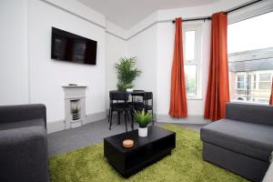 a living room with a couch and a table at 2 Bed Flat near Stadium with Street Parking by CTO Serviced Apartments in Cardiff