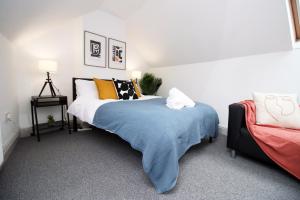 a bedroom with a bed with a blue blanket at 2 Bed Flat near Stadium with Street Parking by CTO Serviced Apartments in Cardiff