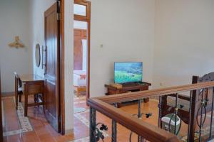 a living room with a television and a table at nDalem Jobali Guesthouse Jogja in Seturan