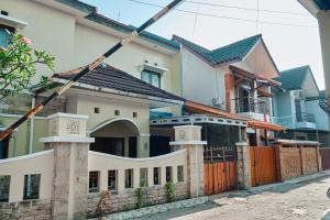 a house with an orange fence in front of it at nDalem Jobali Guesthouse Jogja in Seturan