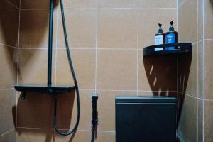 a bathroom with a shower with two bottles of soap at nDalem Jobali Guesthouse Jogja in Seturan +47 photos