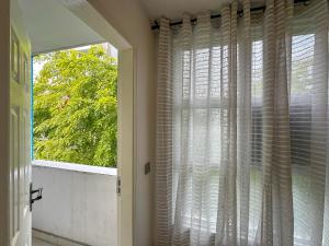 マレにあるModern, Cozy 2-Bedroom Apartmentの木の景色を望む部屋の窓